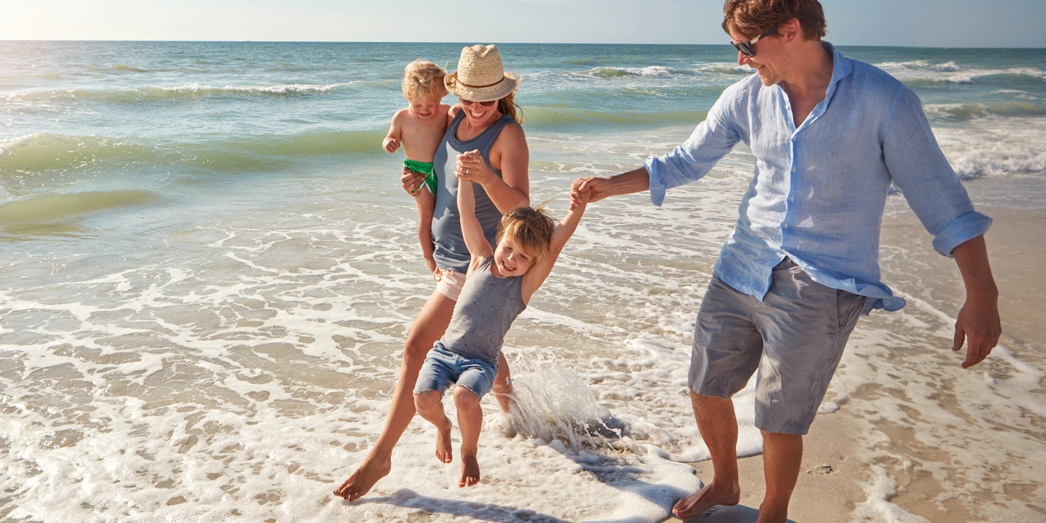 Aufnahme einer jungen Familie, die einen Sommertag am Strand genießt