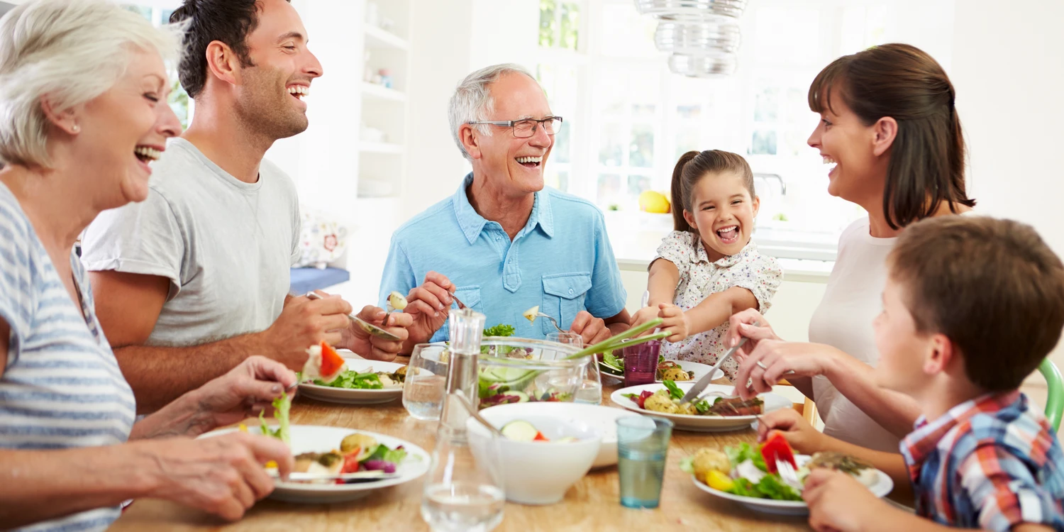 Familie sitzt an einem Tisch