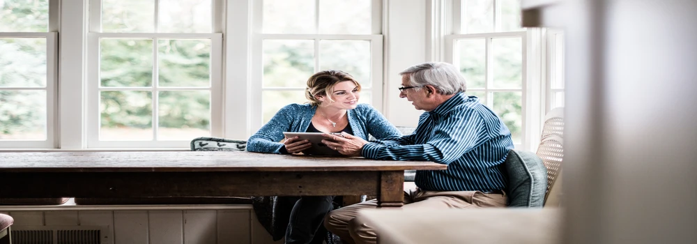 Vater und Tochter sitzen an einem großen Tisch