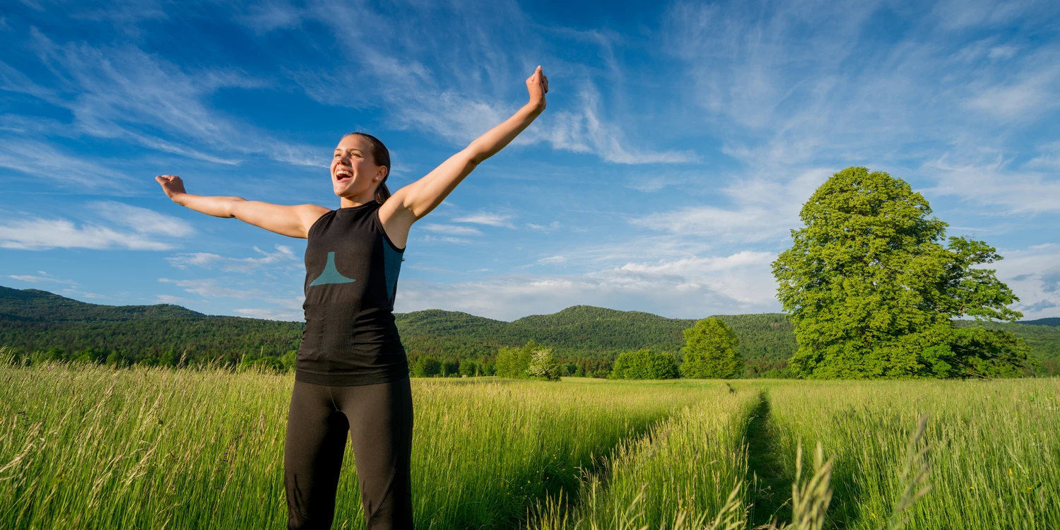 Junge Frau auf einem Feldweg unter blauem Himmel
