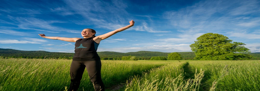 Junge Frau auf einem Feldweg Junge Frau auf einem Feldweg unter blauem Himmel