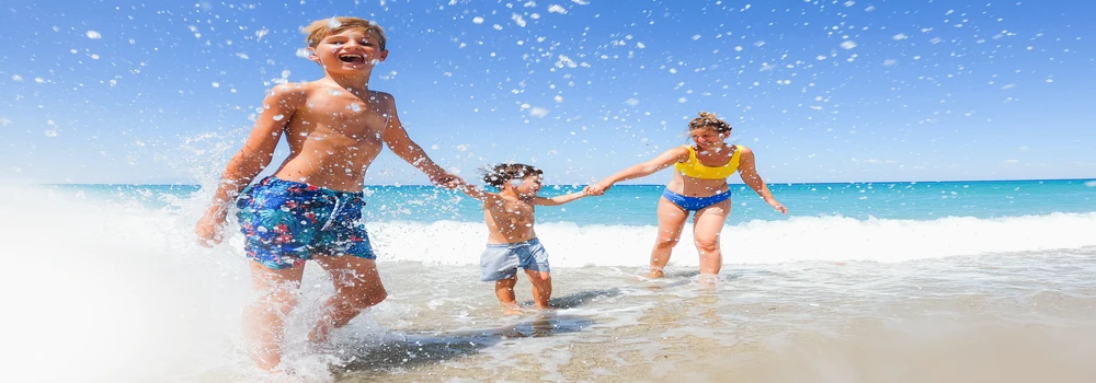 Zwei Kinder und ihre Mutter am Strand