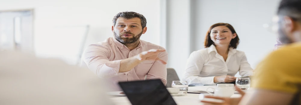 Mehrere Personen kommunizieren an einem Tisch