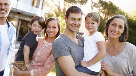 Großfamilie im Garten vor einem Einfamilienhaus