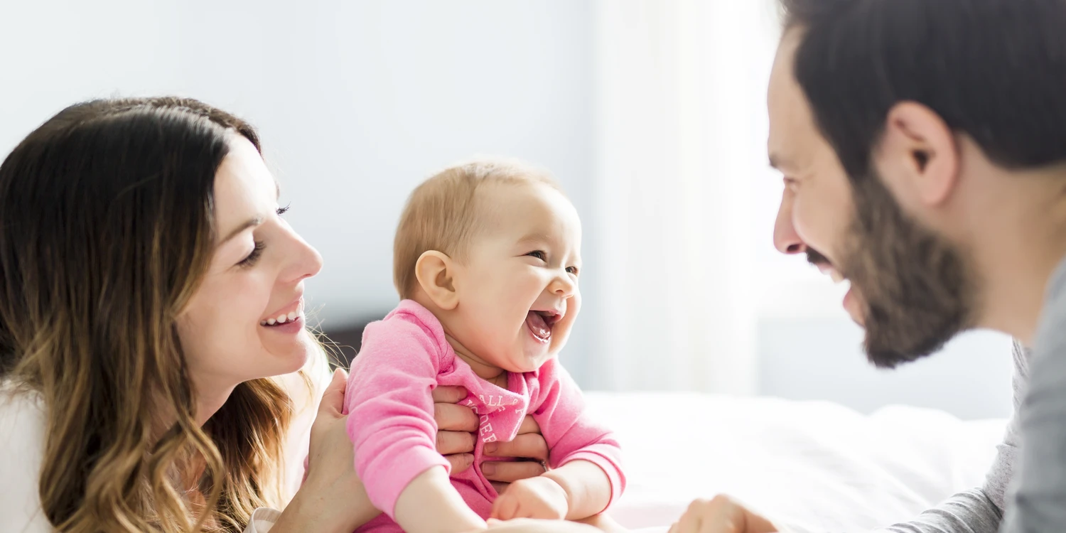 Vater, Mutter, Baby Vater und Mutter mit einem lachenden Baby