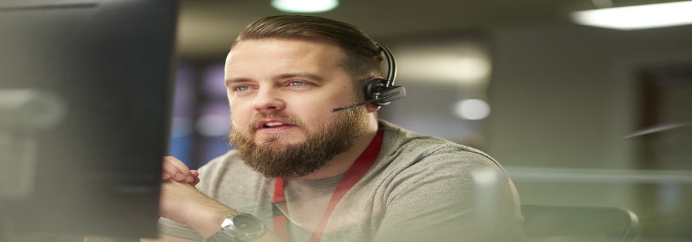 Mann mit Headset am Computer