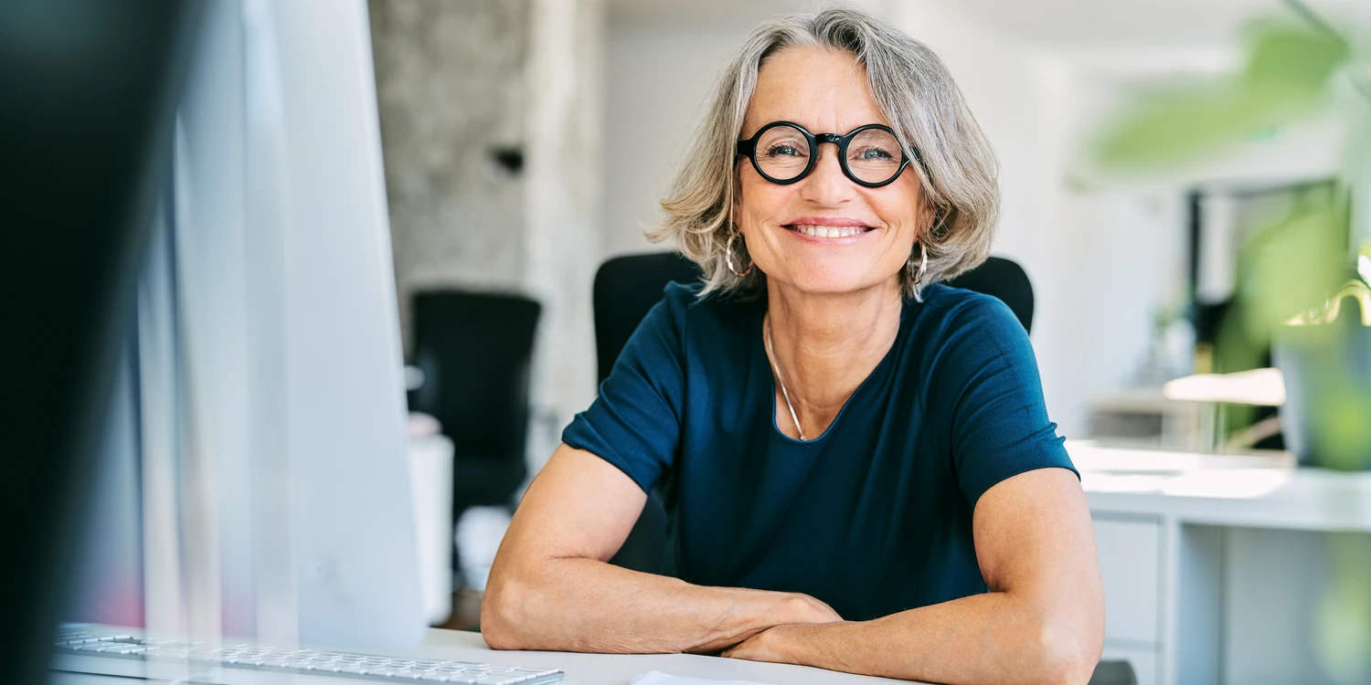 Lächelnde Frau am Schreibtisch