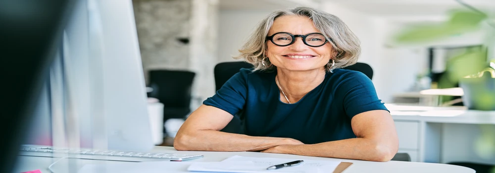 Lächelnde Frau am Schreibtisch
