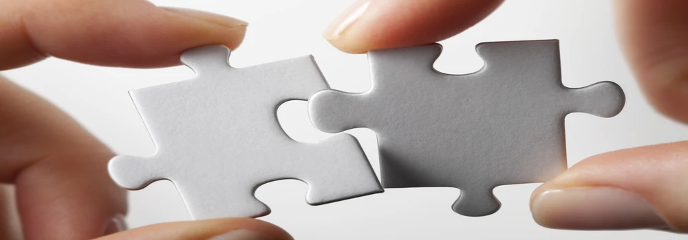 Zwei weiße Puzzleteile werden zusammengefügt