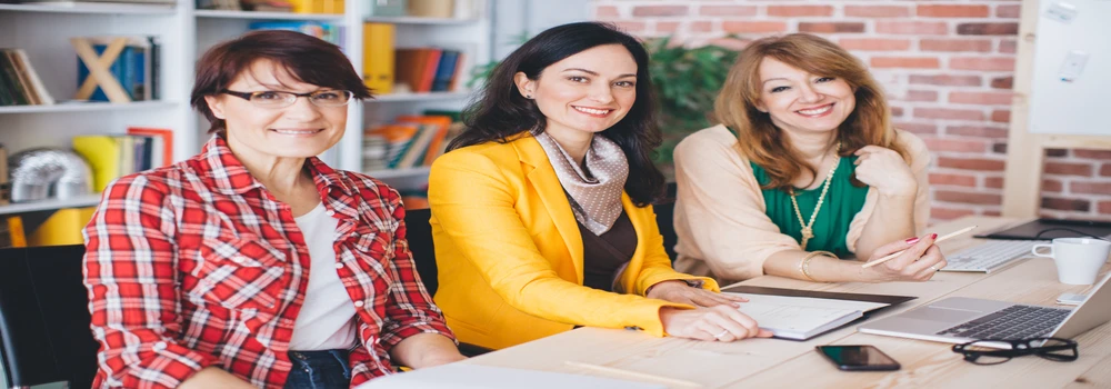 Drei Frauen an einem Schreibtisch