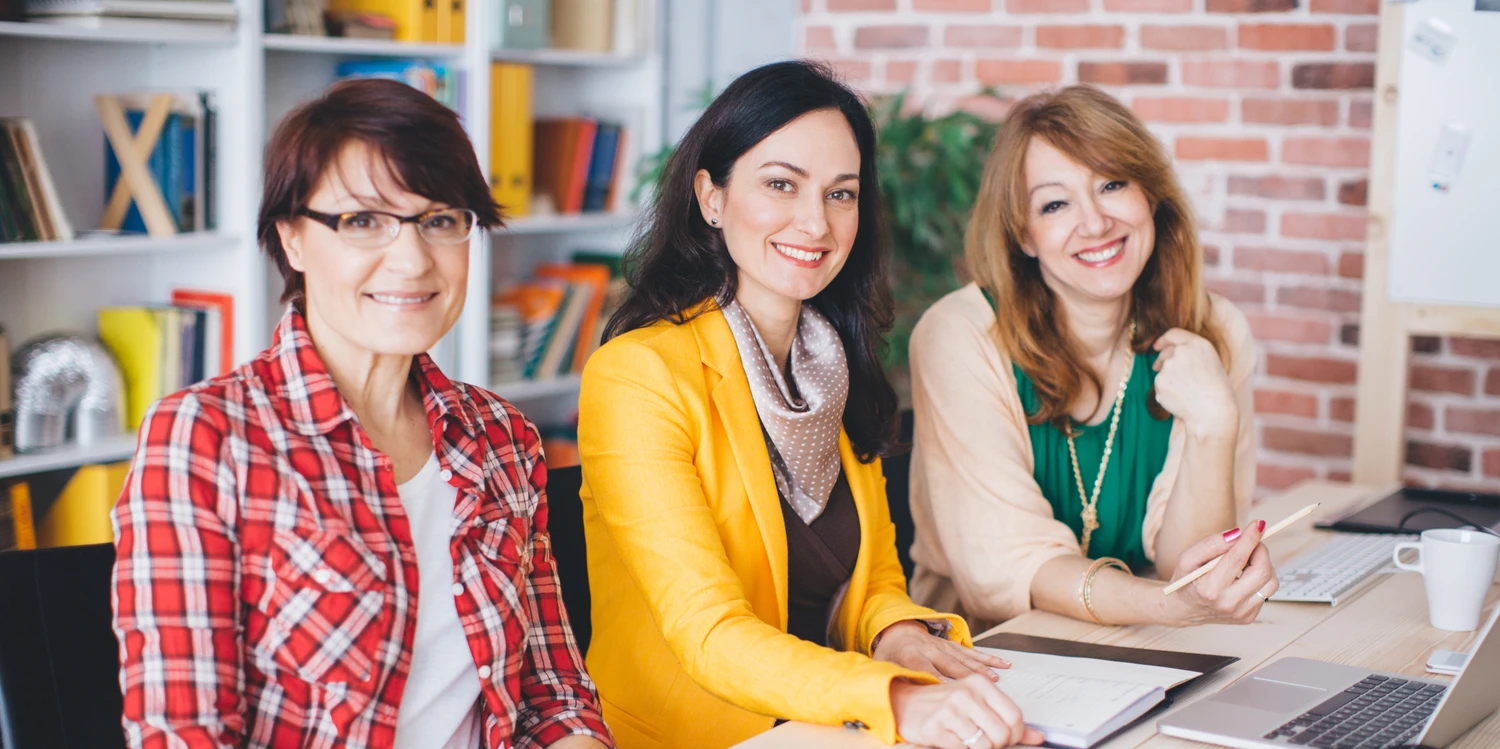 Drei Frauen an einem Schreibtisch